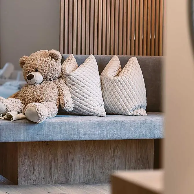 Sitzbank mit kuscheligen Kissen im Familienhotel Kesselgrub